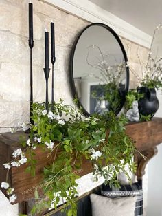 a mirror and some flowers on a mantle