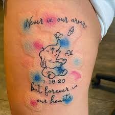 a person with a tattoo on their leg that says never in our arms, but forever in our heart