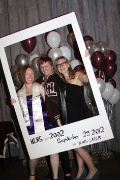 two women and a man are posing for a photo in front of balloons with the number 11 on it