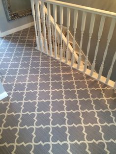 a stair case in a house with grey carpet and white railings