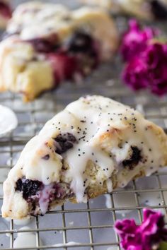 blueberry scones with white icing and sprinkles on a cooling rack