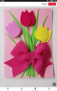 a card with paper flowers and a bow on it