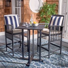 two chairs sitting on top of a blue and white rug next to a wooden table