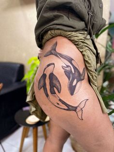 a woman's thigh with an orca whale tattoo on it and her leg