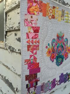 a quilt hanging on the side of a building