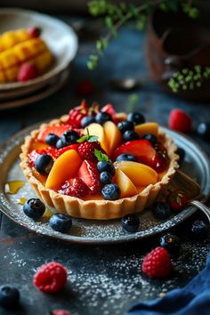 a fruit tart on a plate with berries and blueberries