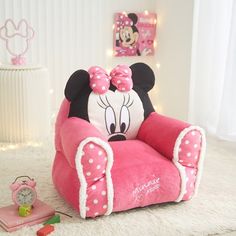 a minnie mouse chair sitting on top of a rug next to a clock and toy