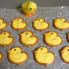 there are many small cookies with yellow icing on the table next to a toy duck