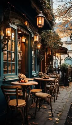 an outdoor cafe with tables and chairs on the sidewalk in front of blue doors, surrounded by autumn leaves