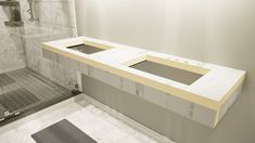 two sinks in the middle of a bathroom with tile flooring and white counter tops