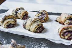 some pastries are sitting on a piece of parchment paper and sprinkled with powdered sugar