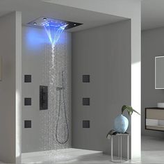 a shower head with blue light coming out of it's side and water running from the faucet