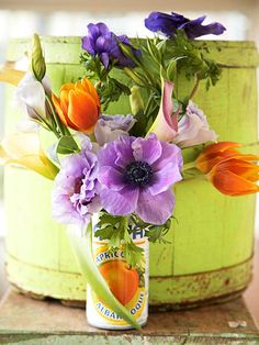 an arrangement of flowers in a can on a table