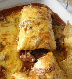 an enchilada on a plate with tortilla chips