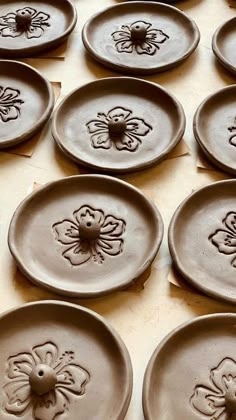 many plates with flower designs on them are lined up in the shape of hearts and flowers