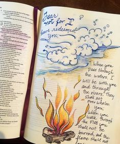 an open book with writing on it and a drawing of a campfire in the background