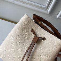 Embossed Monogram Empreinte leather brings a sophisticated feel to the NéoNoé MM bucket bag with its leather drawstring and gold-color eyelets. The body-friendly design and light-weight construction mean it’s comfortable to carry, by hand with the removable top handle or over the shoulder and cross-body, thanks to it detachable and adjustable strap. Detailed Features 10.2 x 10.2 x 6.9 inches (length x Height x Width) Cream and Caramel Embossed Monogram Empreinte grained cowhide leather Cowhide-l Lv Body Bag Louis Vuitton, Louis Vuitton Metallic Bag, Néonoé Mm, Louis Vuitton Neonoe, Mean It, Vuitton Bag, New Bag, Cowhide Leather, Leather Trims