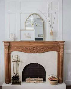 a fireplace in a living room with a mirror on the mantle and other items sitting on top of it