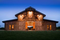 a barn with lights on the windows and doors