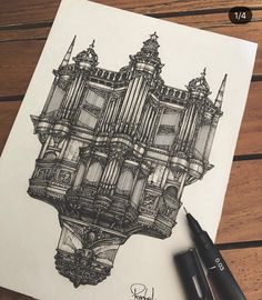 a drawing of a building on paper next to a pen and ink marker with the image drawn in it