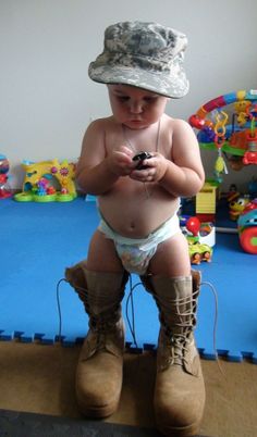 a baby in a hat and diaper playing with a cell phone