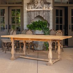 a wooden table with chairs around it in front of a house