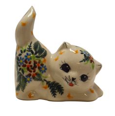 a ceramic figurine of a cat with flowers on it