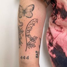 a woman's arm with tattoos on it and butterflies in the middle of her arm