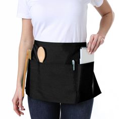 a woman wearing a black apron holding a clipboard and pen