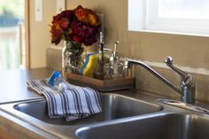 a kitchen sink with a dish towel and soap dispenser