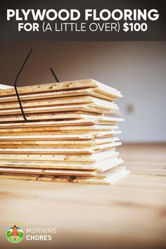 a stack of wooden flooring sitting on top of a table with the title plywood flooring for a little over $ 100