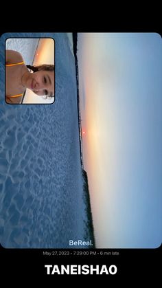 a woman standing next to the ocean in front of a mirror with her reflection on it