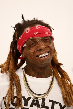 a man with dreadlocks wearing glasses and a red bandana