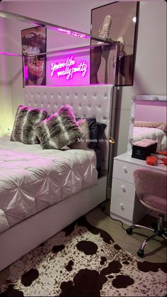 a white bed sitting in a bedroom next to a pink chair and mirror on the wall