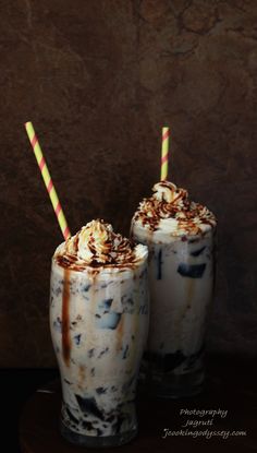 two glasses filled with ice cream and toppings