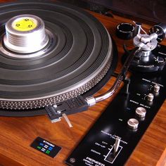 an old record player sitting on top of a wooden table next to other electronic equipment