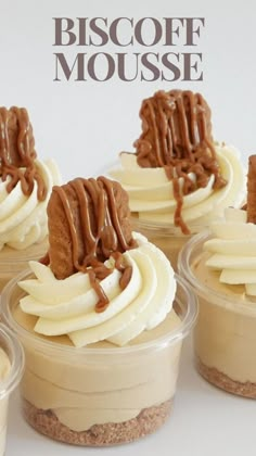 four desserts in small plastic containers with chocolate and cream toppings on the top