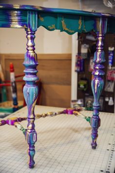 a purple and blue table sitting on top of a piece of paper in a room