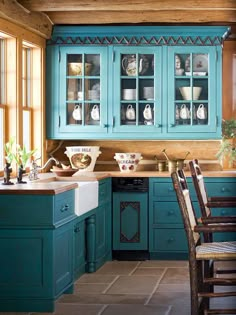 a kitchen with blue cabinetry and wooden floors, along with a dining room table