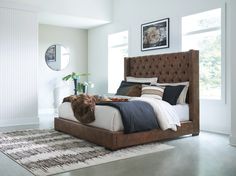 a bedroom with a bed, rugs and pictures on the wall