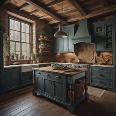 a kitchen with green cabinets and wooden floors, an island in front of the window