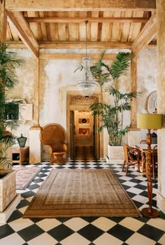 a living room filled with lots of furniture and plants on top of a checkered floor