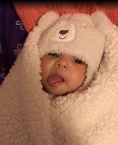 a baby wrapped in a white teddy bear blanket