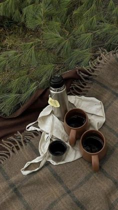 two cups of coffee sitting on top of a blanket