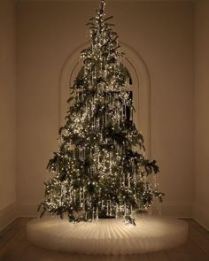 a lit christmas tree in an empty room