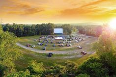 an aerial view of a movie park with cars parked in the lot and trees surrounding it