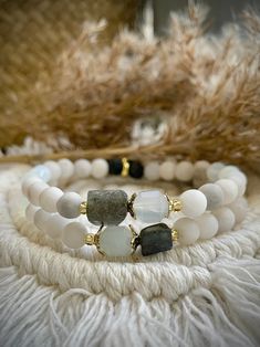 Chalcedony, Lace Agate, Labradorite, Opalite and Gold Hematite, with Lava stone bracelet.  Exquisitely handcrafted with the practical, yet spiritual person in mind.  With a variety of gemstones, this bracelet is the perfect bracelet for everyday wear to garner to positive healing energies like wealth, balance and transformation. The bracelet is paired with White and Black Lava stone-- a natural gemstone that is compounded to effectively absorb heat and oil. Lava in jewelry provides many benefits Natural Gemstone Bracelets, Labradorite Bracelets With Natural Stones For Healing, White Stackable Beaded Bracelets For Healing, Amazonite Stretch Bracelet With Natural Stones As Gift, Labradorite Beaded Bracelets With Natural Stones As A Gift, Everyday Agate Bracelets With Natural Stones, Spiritual Jade Bracelets For Everyday, Natural Stone Bracelet Ideas, Handmade Amazonite Bracelets For Everyday