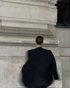 a woman walking down the street in front of a building