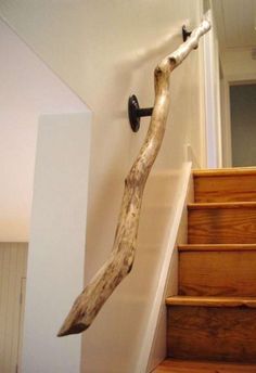 a wooden handrail on the wall next to some stairs