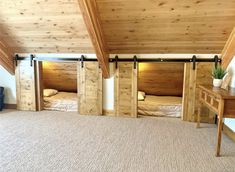 there are three beds in the room with wooden walls and ceiling beams on each side